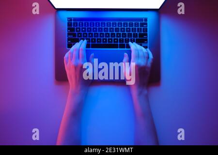 Consente di utilizzare una moderna tastiera per computer portatili, la vista dall'alto è in rosso brillante e lo sfondo blu al neon Foto Stock