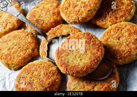 Torte di pesce bianco di filetto di pesce bianco: merluzzo o eglefino con patate e prezzemolo, impanate in pangrattato e poi cotte in forno, servite su un foglio pa Foto Stock