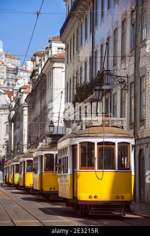 Molti tram gialli parcheggiati in una delle strade principali della città di Lisbona. Portogallo. Foto Stock