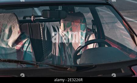 I sedili di un'auto d'epoca rossa ricoperta di asciugamani colorati (Marche, Italia, Europa) Foto Stock