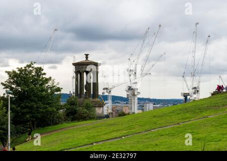 Blick vom Calton Hill über das Dugald Stewart Monument auf N Edinburgh mit Baukranen Foto Stock