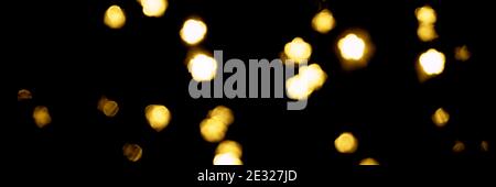 Gold bokeh stelle su sfondo nero. Sfondo con glitter giallo. Consistenza dorata Foto Stock Gold bokeh stelle su sfondo nero. Sfondo con glitter giallo. Consistenza dorata Foto Stock