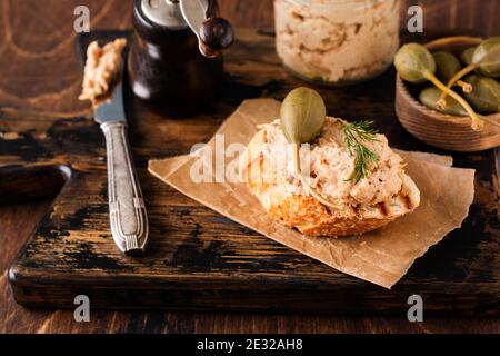 Sandwich con pate di pollo con cappero su un vecchio sfondo scuro della tavola. Messa a fuoco selettiva Foto Stock