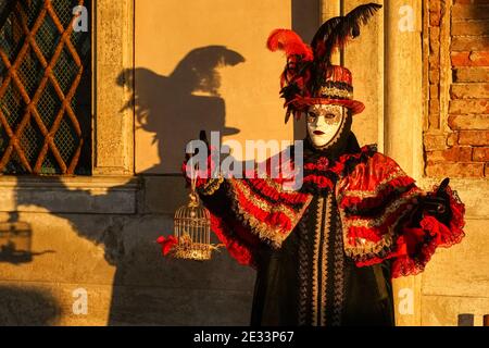 Uomo vestito con costumi tradizionali decorati e maschere dipinte durante il Carnevale di Venezia Foto Stock