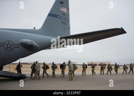 Bismarck, Stati Uniti. 15 gennaio 2021. I soldati statunitensi con la Guardia Nazionale dell'Esercito del Nord Dakota salirono a bordo di un aereo da trasporto C-130H2 mentre si dirigono verso l'inaugurazione il 15 gennaio 2021 a Bismarck, North Dakota. Più di 20,000 truppe di guardia nazionali sono state impiegate per fornire sicurezza in seguito all’insurrezione da parte dei riotatori Pro-Trump. Credit: Planetpix/Alamy Live News Foto Stock