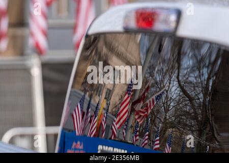 I riflessi delle bandiere sono visti in un riflesso di una finestra di un camion da lavoro mentre si svolgono i preparativi per l'inaugurazione del presidente Joe Biden presso lo stand di osservazione di fronte alla Casa Bianca 16 gennaio 2021 a Washington DC. La sicurezza è ancora più rigida, dati i recenti eventi in cui i MAGA pro-Trump hanno violato il perimetro della sicurezza e sono penetrati nel Campidoglio degli Stati Uniti il 6 gennaio. Credito: Ken Cedeno/Pool via CNP /MediaPunch Foto Stock