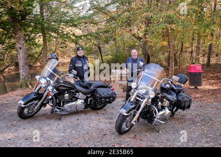 Due motociclette Harley Davidson nere parcheggiate e i loro piloti indossano pelli nere. Foto Stock