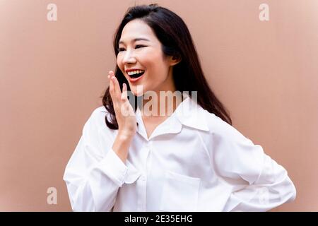 20s giovane asiatica felice millennial donna in camicia bianca dentro sfondo pulito sorridente Foto Stock