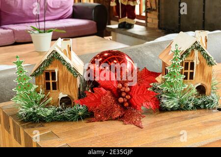 Decorazione di Natale, due mini case di legno e una grande palla rossa. Foto Stock