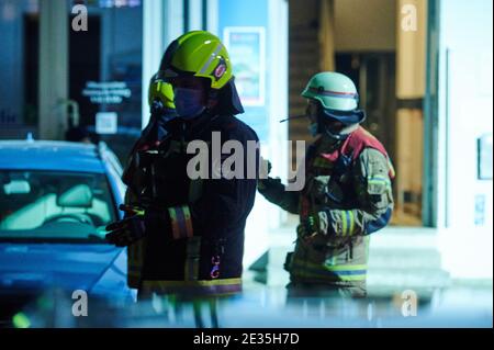 Berlino, Germania. 17 gennaio 2021. Tre vigili del fuoco si trovano di fronte all'ingresso della casa. Nel Muthesiusstraße di Steglitz è scoppiato un incendio nel cortile del 1° piano per motivi ancora inspiegabili. Il fuoco si sparse al 2° piano. Il reparto vigili del fuoco era sulla scena con circa 60 vigili del fuoco. (A dpa: 'Incendio nell'edificio di appartamenti Berlino - una persona risuscitata') Credit: Annette Riedl/dpa/Alamy Live News Foto Stock