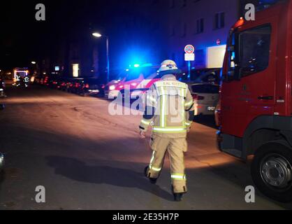 Berlino, Germania. 17 gennaio 2021. Un pompiere corre accanto a un veicolo di emergenza. Nel Muthesiusstraße di Steglitz è scoppiato un incendio nel cortile del 1° piano per motivi ancora inspiegabili. Il fuoco si sparse al 2° piano. Il reparto vigili del fuoco era sulla scena con circa 60 vigili del fuoco. (A dpa: 'Incendio nell'edificio di appartamenti Berlino - una persona risuscitata') Credit: Annette Riedl/dpa/Alamy Live News Foto Stock