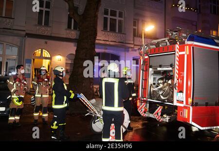 Berlino, Germania. 17 gennaio 2021. Cinque vigili del fuoco si trovano dietro un veicolo e un carico di emergenza. Nel Muthesiusstraße di Steglitz è scoppiato un incendio nel cortile del 1° piano per motivi ancora inspiegabili. Il fuoco si sparse al 2° piano. Il reparto vigili del fuoco era sulla scena con circa 60 vigili del fuoco. (A dpa: 'Incendio nell'edificio di appartamenti Berlino - una persona risuscitata') Credit: Annette Riedl/dpa/Alamy Live News Foto Stock