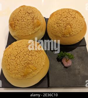 Tre pane croccante di ananas sul piatto nero per mangiare Foto Stock