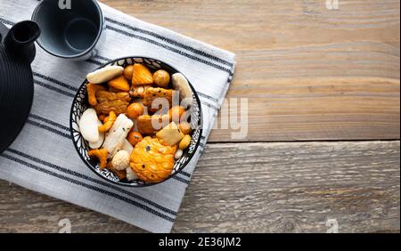 Mescolare i cracker di riso Sennei in un recipiente. Un delizioso spuntino giapponese. Foto Stock