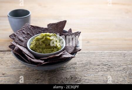 Tortilla di mais blu con guacamole fatte in casa sul lato. Foto Stock