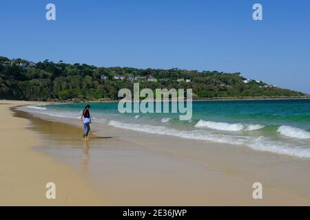 Donna sulla spiaggia a Carbis Bay vicino a St Ives in Cornovaglia, Regno Unito. Foto Stock