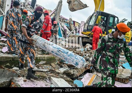 Mamuju, Indonesia. 17 gennaio 2021. I soldati allontanano i detriti mentre cercano le vittime. A seguito del terremoto di grandezza 6.2 che ha colpito il 15 gennaio 2021 e ha ucciso almeno 56 persone, centinaia sono stati feriti e migliaia di residenti sono stati evacuati. Credit: SOPA Images Limited/Alamy Live News Foto Stock