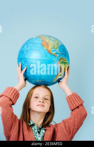 Ragazza dai capelli rossi con un globo nelle mani Foto Stock