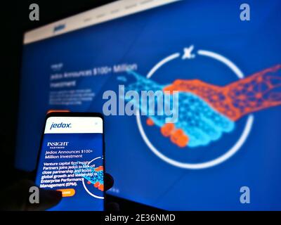 Persona che detiene telefono cellulare con sito web della società tedesca di sviluppo software Jedox AG visualizzato sullo schermo. Concentrarsi sul display dello smartphone. Foto Stock