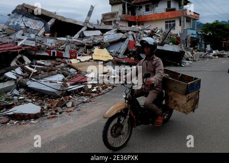 Mamuju, Indonesia. 17 gennaio 2021. I residenti passano attraverso l'area delle macerie dopo il terremoto di magnitudine 6.2 a Mamuju City, Sulawesi Ovest. (Foto di Zul Kifli/Pacific Press) Credit: Pacific Press Media Production Corp./Alamy Live News Foto Stock