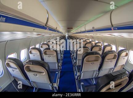 aereo vuoto, cabina di trasporto passeggeri, lungo corridoio blu con comodi posti a sedere Foto Stock