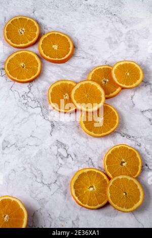Fette arancioni fresche splendidamente sistemate su un tavolo di marmo bianco Foto Stock