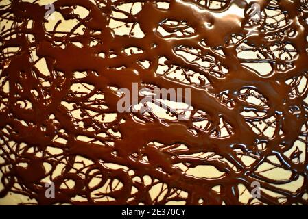 Linee di cioccolato sulla torta dolce. Pittura astratta casuale di cioccolato. Foto Stock