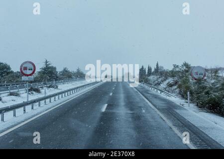 I cartelli stradali verticali vietano di sorprendere i camion con neve in un giorno di condizioni meteorologiche avverse a causa di nevicate. Foto Stock