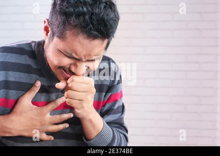 giovane asiatico tosse e starnuti da vicino Foto Stock