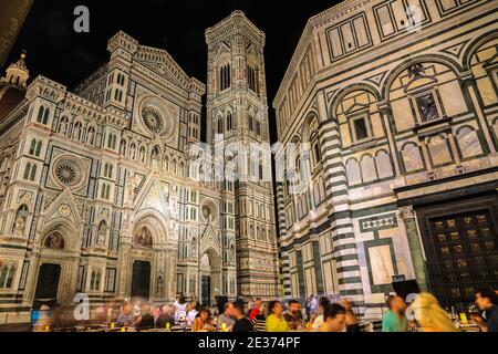 La gente cena fuori da un ristorante di fronte alla famosa Cattedrale di Firenze Santa Maria del Fiore, il Campanile di Giotto e il... Foto Stock