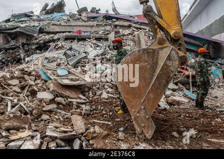 Mamuju, Indonesia. 17 gennaio 2021. Gli uomini dell'esercito indonesiano si trovano nei pressi di un edificio danneggiato dopo che un terremoto di 6.2 magnitudo ha colpito Mamuju, Sulawesi Occidentale, Indonesia, 17 gennaio 2021. Credit: Opan/Xinhua/Alamy Live News Foto Stock