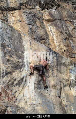 Cima corda arrampicata rocce o top ropping, sistema di ancoraggio in cima alla salita e giù a un credente ai piedi della salita. Foto Stock