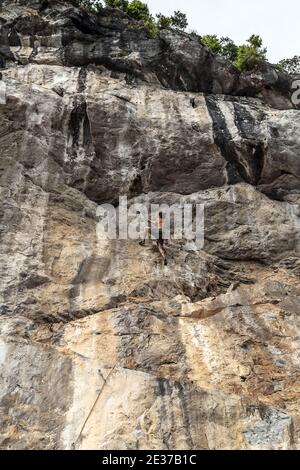 Cima corda arrampicata rocce o top ropping, sistema di ancoraggio in cima alla salita e giù a un credente ai piedi della salita. Foto Stock