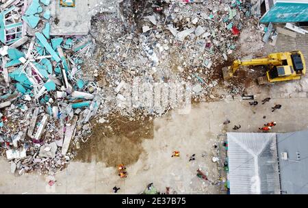 Mamuju, Indonesia. 17 gennaio 2021. La foto aerea mostra un escavatore che lavora su edifici danneggiati durante un'operazione di ricerca dopo un terremoto di 6.2 magnitudo a Mamuju, Sulawesi Occidentale, Indonesia, 17 gennaio 2021. Il bilancio delle vittime di un terremoto di 6.2 magnitudo che ha colpito la provincia indonesiana del Sulawesi occidentale è salito a 73 con oltre 27,000 persone che prendono rifugio, ha detto l'Agenzia Nazionale per la Gestione dei disastri. Credit: Niaz Syarief/Xinhua/Alamy Live News Foto Stock