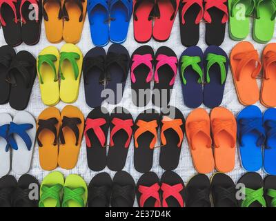 Sandali in gomma colorati e confortevoli realizzati in gomma per la vendita nella zona del mercato locale. File di belle pantofole multicolore Foto Stock