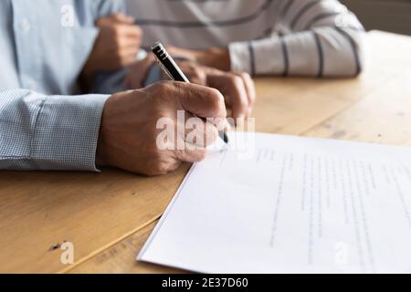 Primo piano su anziano famiglia anziana coppia firma documento cartaceo. Foto Stock