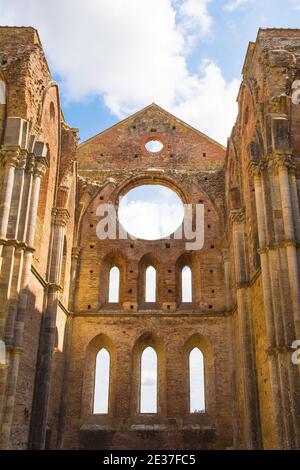 Chiusdino,Italia-7 settembre 2020.la grande finestra circolare e le più piccole finestre ad arco o raggio nei resti dell'abbazia senza tetto di San Galgano, Toscana Foto Stock