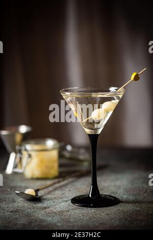 Cocktail Gibson con martini e cipolle in bicchiere martini. Cocktail decorato su sfondo scuro Foto Stock