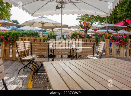 un idilliaco giardino di birra con posti a sedere, tavoli e ombrellone Foto Stock