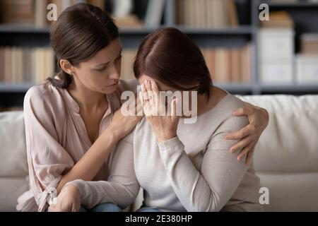 Primo piano la figlia grunnup premurosa che conforta la madre matura infelice Foto Stock