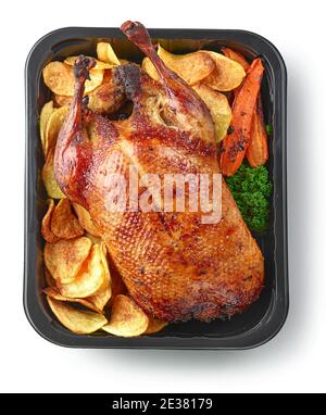 arrosto di anatra appena tostato e verdure in contenitore di plastica pronto per la consegna isolato su sfondo bianco, vista dall'alto Foto Stock