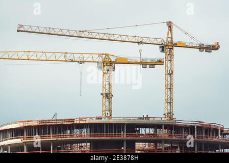 Profilati in acciaio di un edificio in costruzione, con due gru a torre sulla parte superiore. Strutture in cemento armato Foto Stock