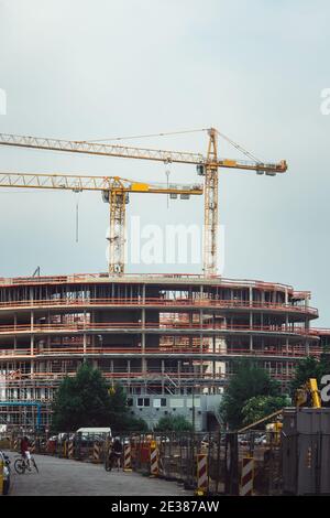 Profilati in acciaio di un edificio in costruzione, con due gru a torre sulla parte superiore. Strutture in cemento armato Foto Stock