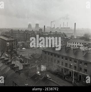 Anni '60, storica, Londra sud-est, Inghilterra, una vista dello skyline e sui tetti della zona, mostrando la tradizionale casa vittoriana terrazza, un ospedale vittoriano, il Miller General Hospital a Greenwich & Lewisham e altri edifici e in lontananza, I camini fumanti delle molte fabbriche che esistevano ancora nel centro di Londra in quest'epoca. Foto Stock