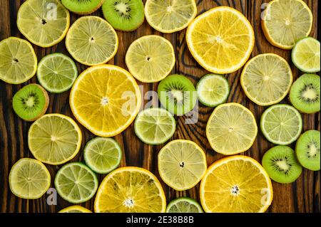 Fette fresche di kiwi e limone su sfondo giallo Foto Stock