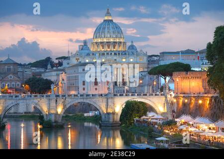 Vista notturna di Ponte Sant'Angelo e la Basilica di San Pietro in Roma, Italia Foto Stock