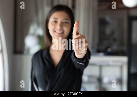 Primo piano sorridente imprenditore indiano mostrando pollici in su alla macchina fotografica Foto Stock