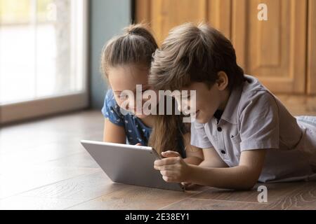 I bambini piccoli felici si divertono a usare il tablet insieme Foto Stock