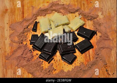 Diversi tipi di cioccolato in un cerchio di cacao su superficie di legno. Foto Stock