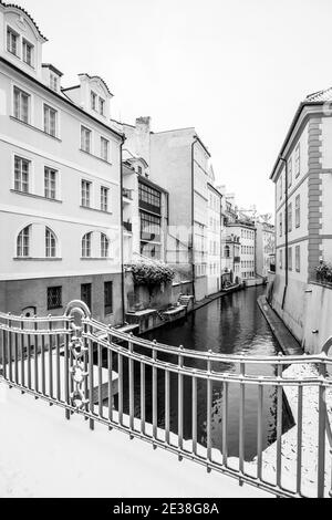 Inverno a Praga Venezia. Case residenziali a Devils Stream o Devils Channel, ceco: Certovka, vicino Ponte Carlo a Praga, Repubblica Ceca. Immagine in bianco e nero. Foto Stock